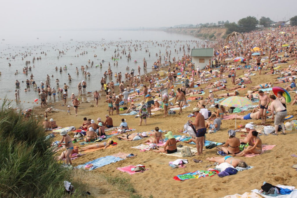Пляж на озере с большим количеством людей