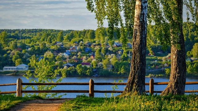 За речкой небольшой городок утопает в зелени леса